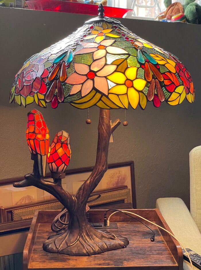 Stained glass floral lamp with bird-shaped lights on a wooden tree-branch base found in thrift store jackpot haul.