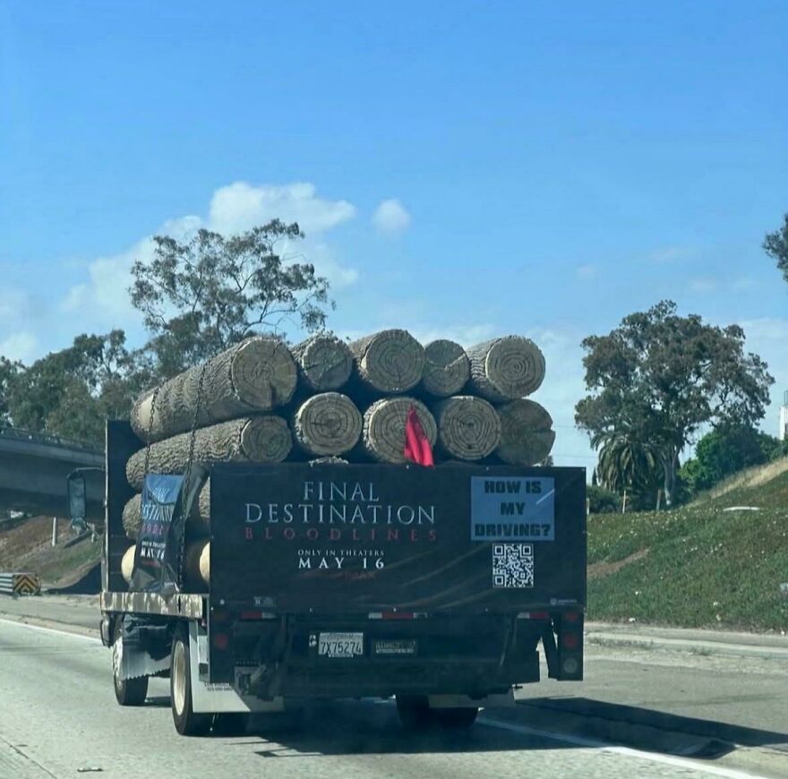 Truck loaded with large logs on highway, showing risky load securing in a clear daytime setting for times people knew exactly what they were doing.