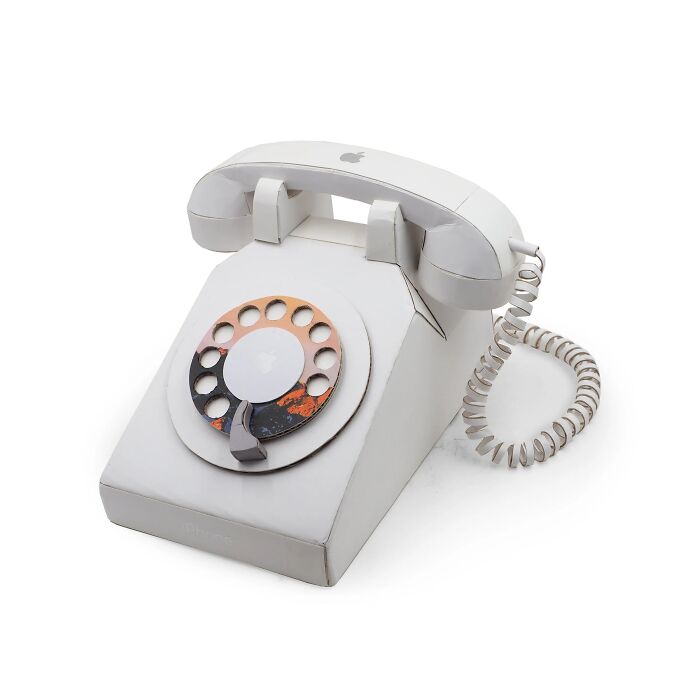 Vintage rotary dial telephone sculpture made from recycled materials, showcasing witty commentary on modern life through art.