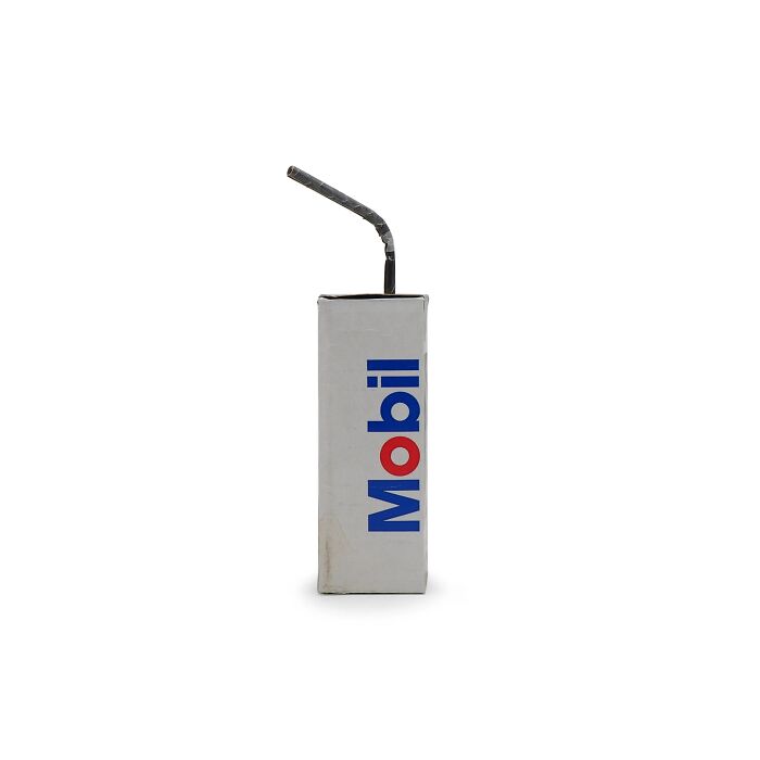 Artistic sculpture made from waste materials resembling a juice box with a bent straw, highlighting modern life commentary.