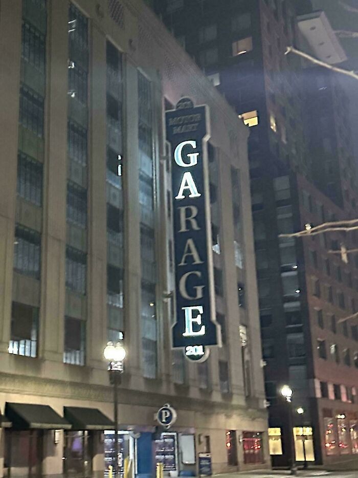 Illuminated LED garage sign on a city building at night, showcasing vintage style in an urban setting.