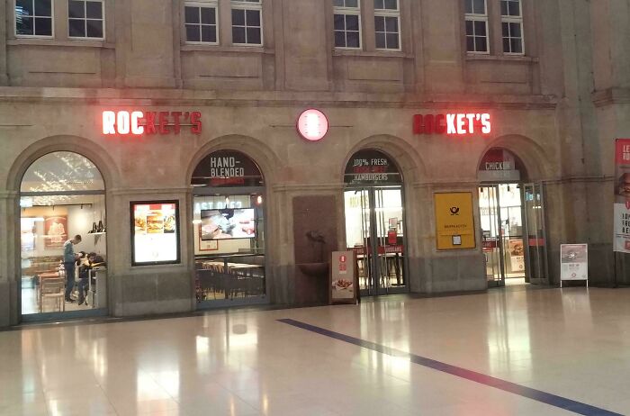 LED signs displaying restaurant name Rocket's in a modern indoor setting with illuminated text on a stone building facade.