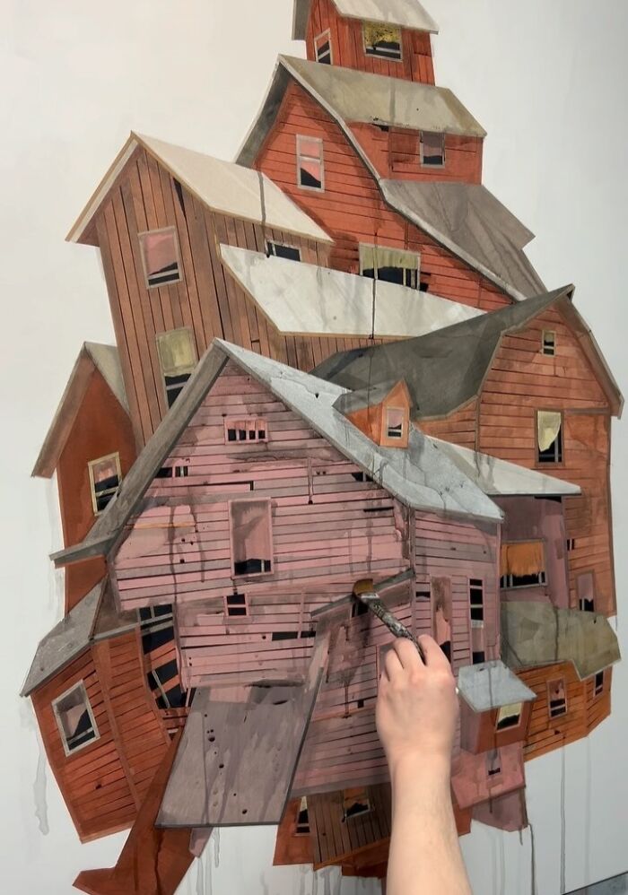 Hand painting a surreal collage of walking and collapsing buildings with layered wooden structures in various shades of brown.