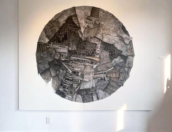 Surreal collage artwork depicting buildings that seem to collapse and walk, displayed on a white gallery wall.