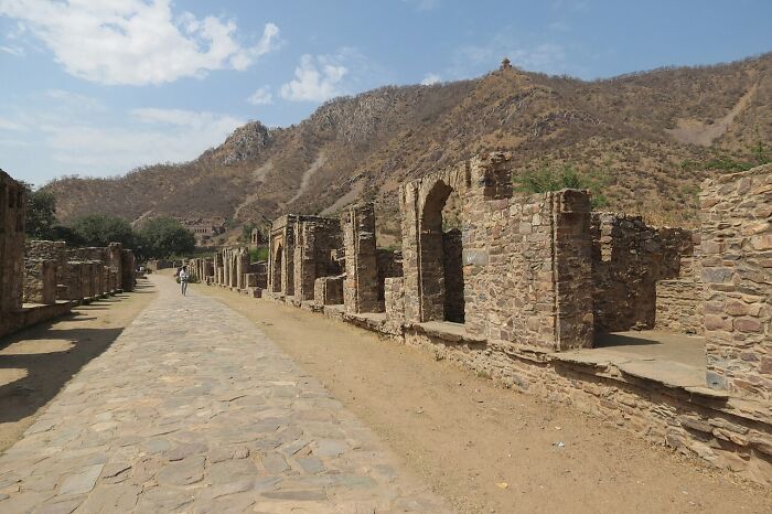 Ancient stone ruins along a deserted pathway with arid hills in the background at spooky destinations for Halloween visitors
