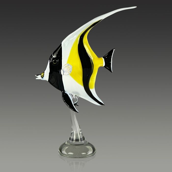 Glass sculpture of a colorful tropical fish showcasing stunning ocean life craftsmanship on a clear stand against a gray background.