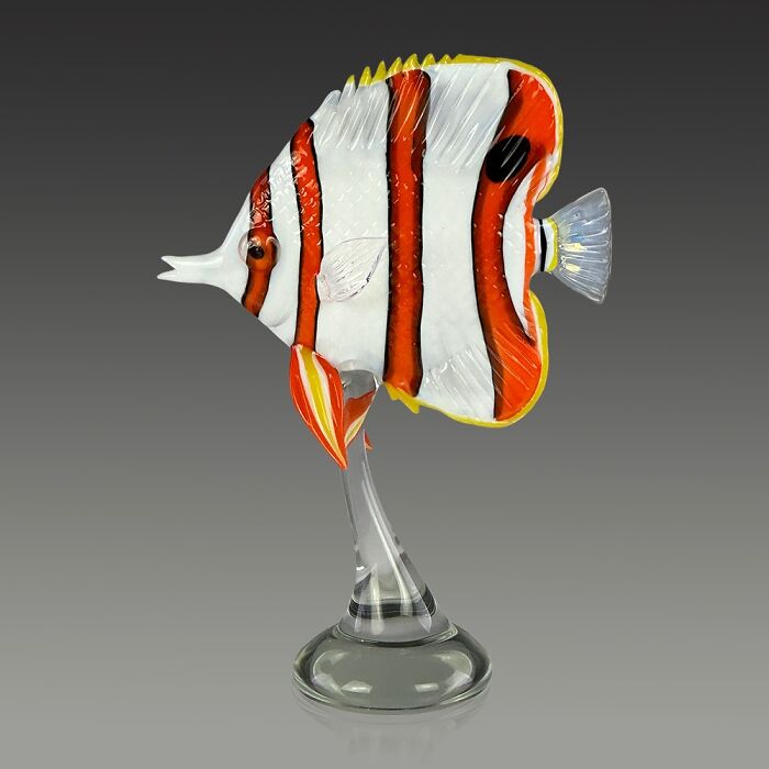 Glass sculpture of a colorful tropical fish showcasing stunning ocean life artistry on a clear glass stand.