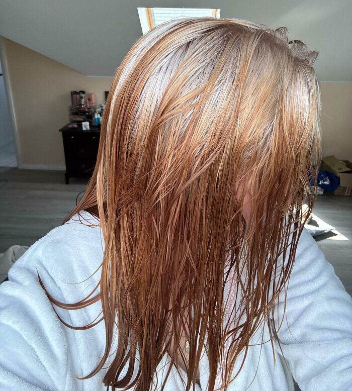 Wet hair with uneven, patchy color, showing a likely hair accident in a casual indoor setting.