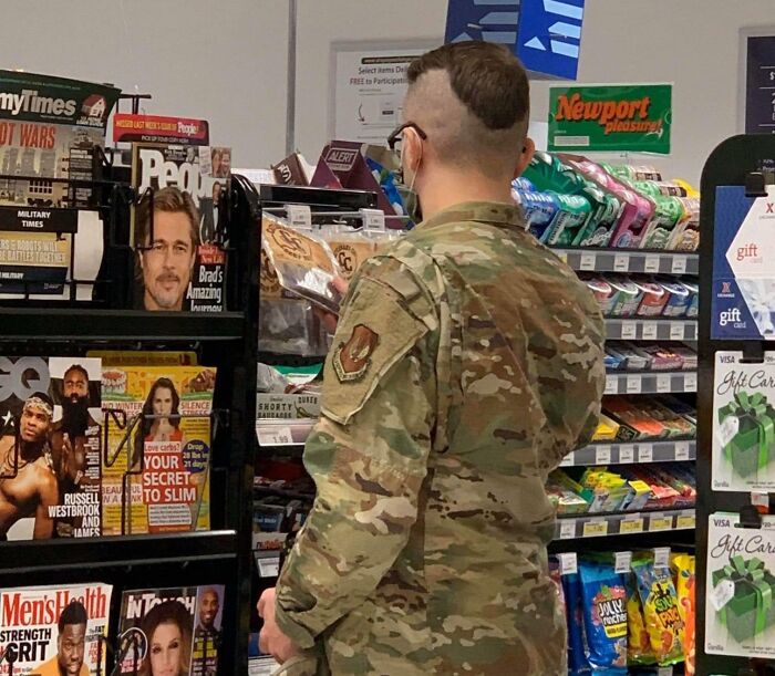 Man in military uniform with a tragic hair accident featuring an uneven, partially shaved head at a convenience store.