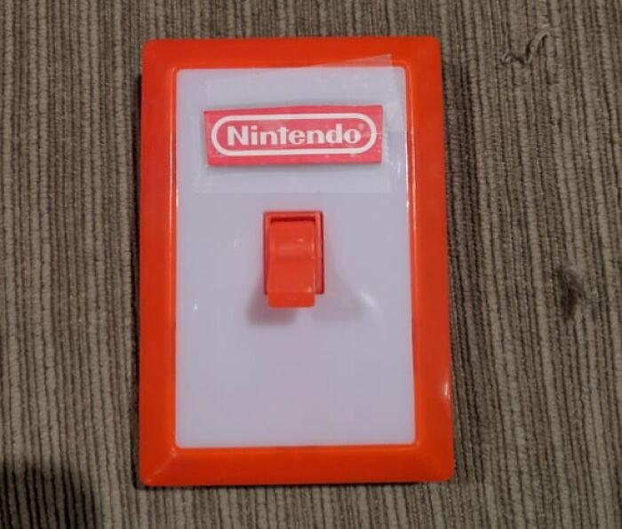 Nintendo light switch cover on a carpet, showcasing a creative and unhinged take on people doing exactly what they were asked to do.