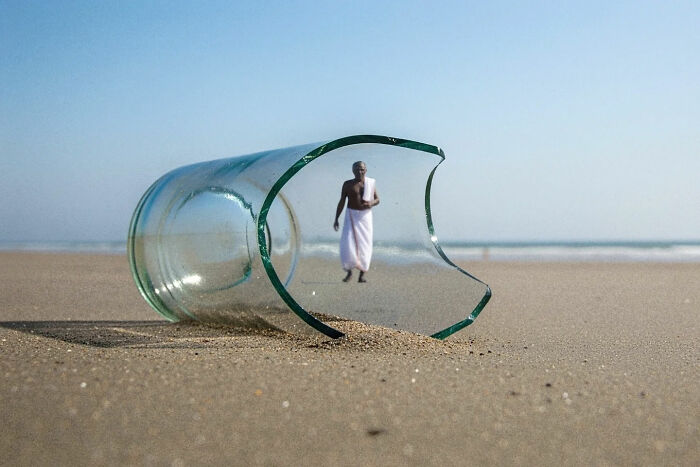 Broken glass on the beach with a man in traditional attire captured inside, showcasing everyday life in India by street photographer.