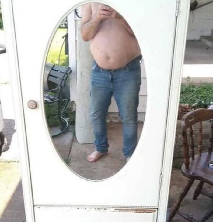 Man with bare torso and jeans reflected in a vintage white mirror for sale, highlighting the reflection that sells it.