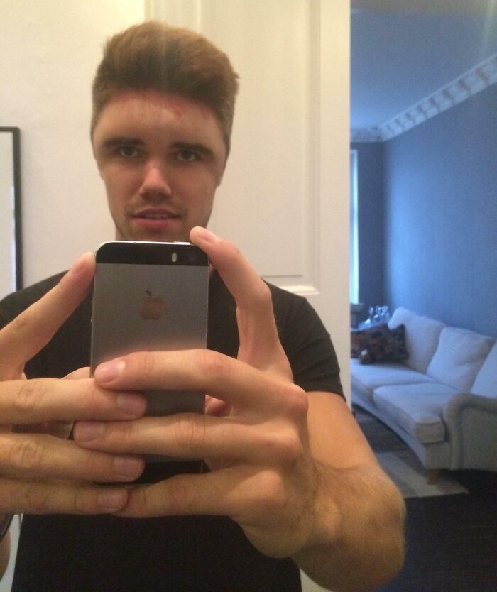 Young man taking a selfie showing a hilariously tragic hair accident with uneven and oddly shaped haircut.