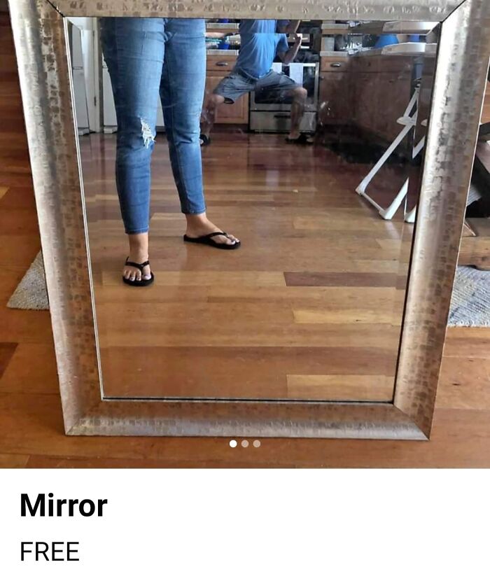 Mirror listing showing reflection of person wearing ripped jeans and sandals in a kitchen setting with wooden floors.