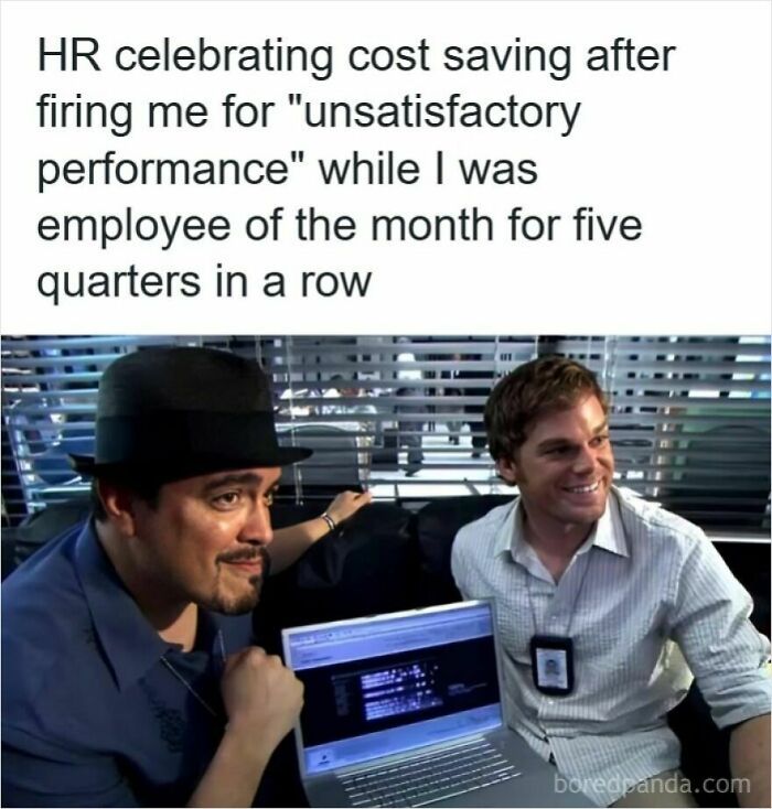 Two men smiling in an office setting with a laptop, illustrating humor about getting laid off and workplace frustration.