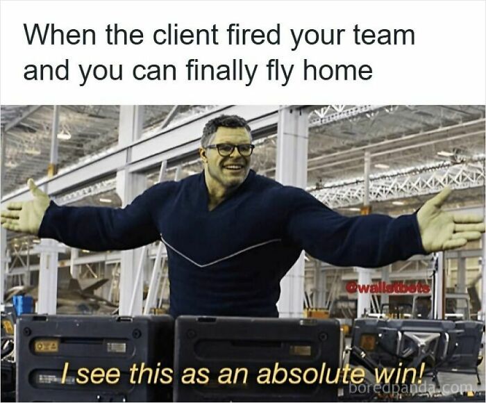 Man with outstretched arms smiling in a warehouse with text about getting laid off as an absolute win meme.