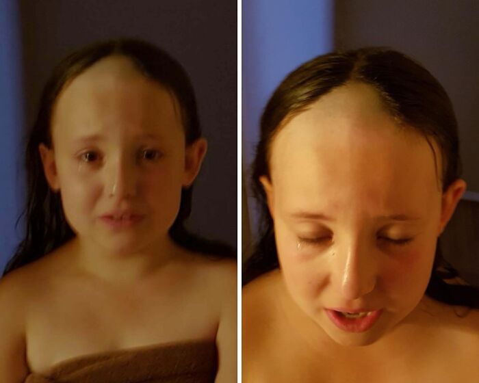 Young girl crying with a hilariously tragic hair accident showing an uneven shaved forehead and wet hair in dim lighting.