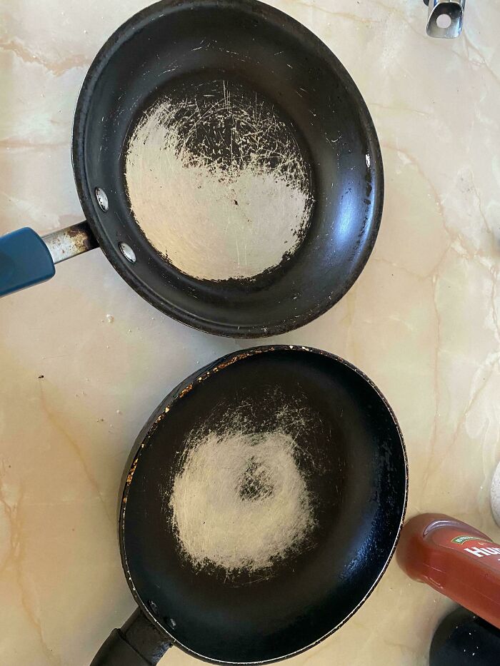 Two nonstick frying pans with worn, scratched surfaces showing heavy family frustration and venting online.