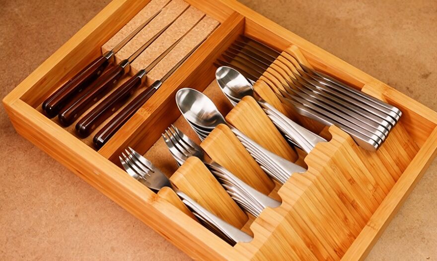Wooden utensil drawer organizer neatly storing knives, forks, spoons, showcasing smart organization hacks for the home.