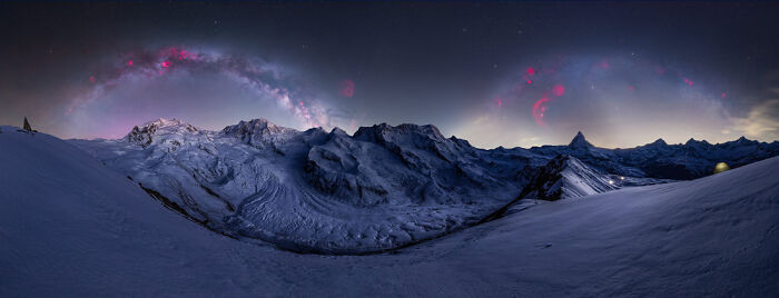 Panoramic snowy mountain landscape under a starry sky with vibrant cosmic colors, showcasing panoramic masterpieces in nature.