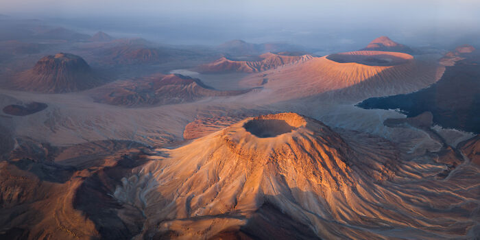 A stunning panoramic masterpiece showcasing volcanic craters and rugged terrain captured in warm sunlight for Epson Pano Awards.