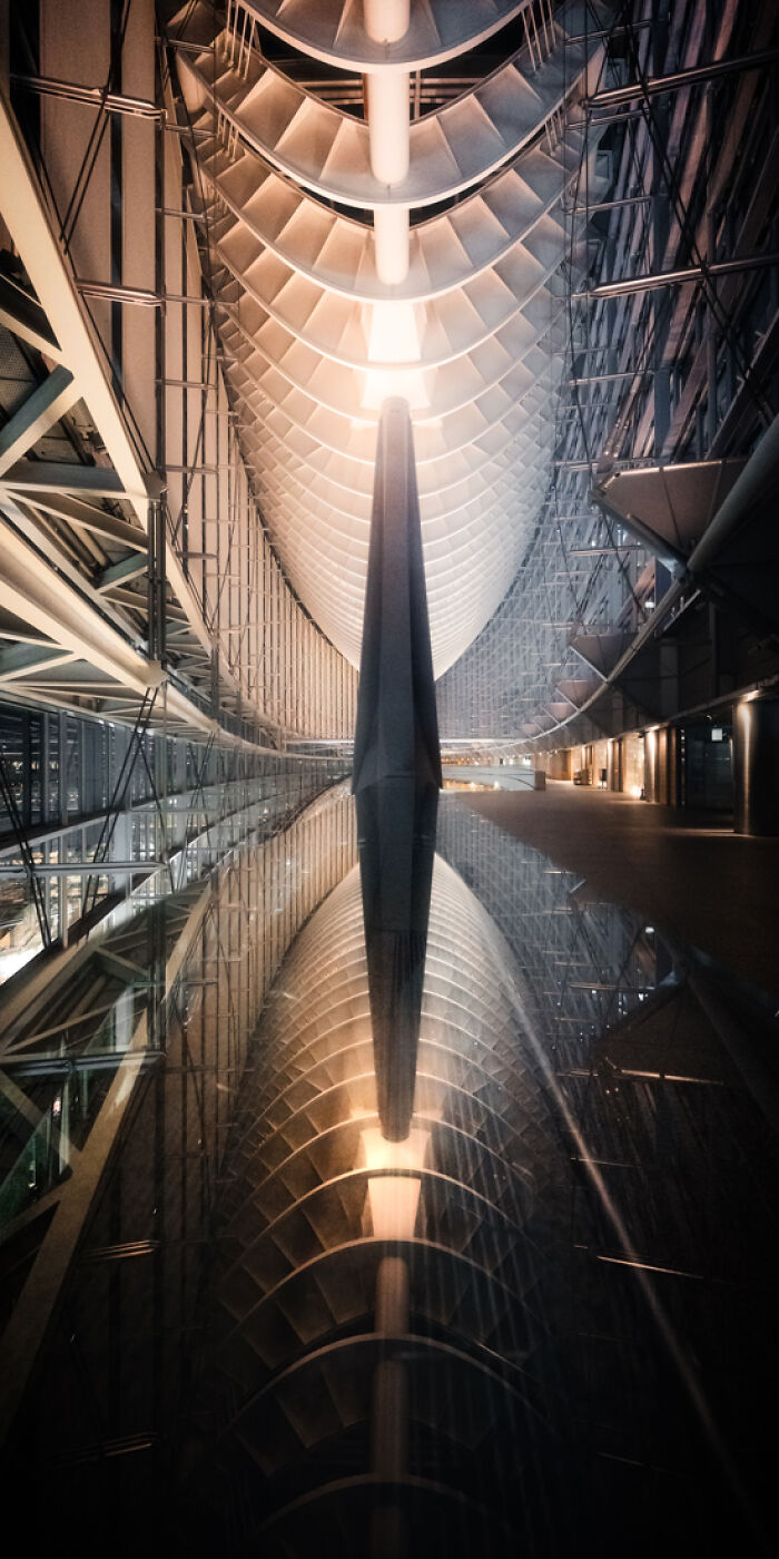 Futuristic architectural structure with symmetrical design and reflections showcasing panoramic masterpieces in an award-winning style.