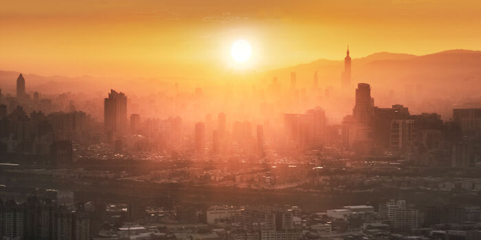 Panoramic cityscape at sunrise with golden light and hazy skyline, showcasing stunning panoramic masterpieces from Epson Pano Awards.