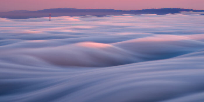 Panoramic landscape of soft, flowing clouds over hills at sunrise, showcasing stunning Epson Pano Awards 2025 masterpiece.