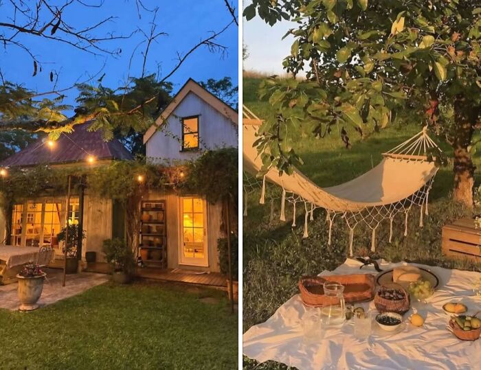 Cozy dream cottage illuminated at dusk with a peaceful garden featuring a hammock and outdoor picnic setup.