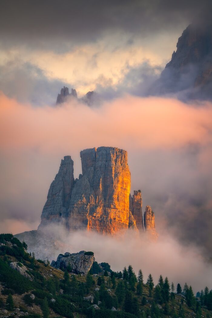 Majestic mountain peaks glowing in sunset light surrounded by mist in a stunning nature photography finals image. Majestic mountain peaks glowing in sunset light surrounded by mist in a stunning nature photography finals image.