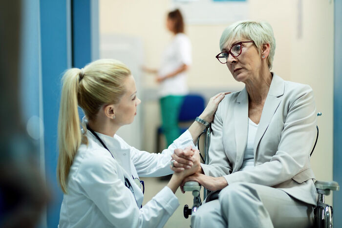 Doctor comforting a distressed patient in a hospital hallway, reflecting scary ghost stories hospital work atmosphere.