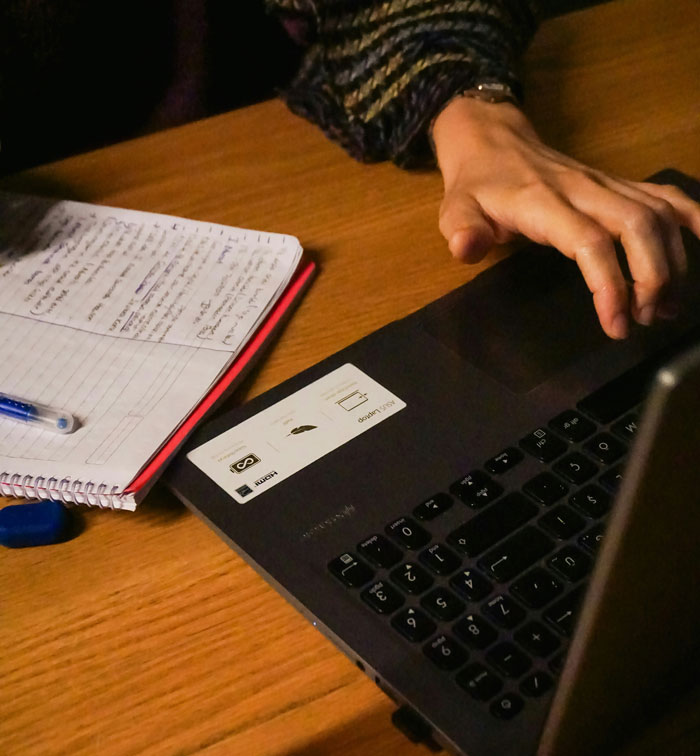 Person using laptop and handwritten notes, researching couple wedding sabotage by parents days before ceremony.