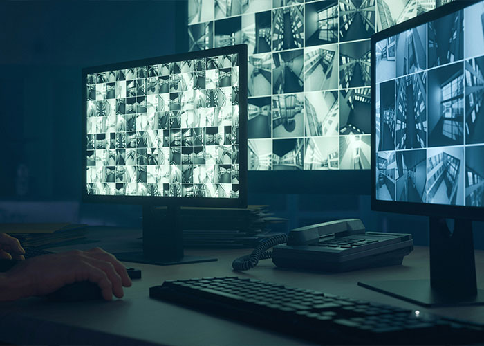 Surveillance monitors displaying multiple camera feeds in a dark room, linked to rental house security after disturbing discovery. Surveillance monitors displaying multiple camera feeds in a dark room, linked to rental house security after disturbing discovery.