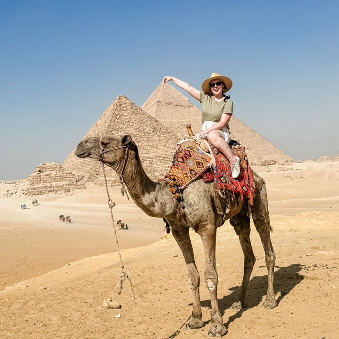 Woman riding a camel near pyramids in the desert, symbolic image for pregnant Disney superfan found lifeless news. Woman riding a camel near pyramids in the desert, symbolic image for pregnant Disney superfan found lifeless news.