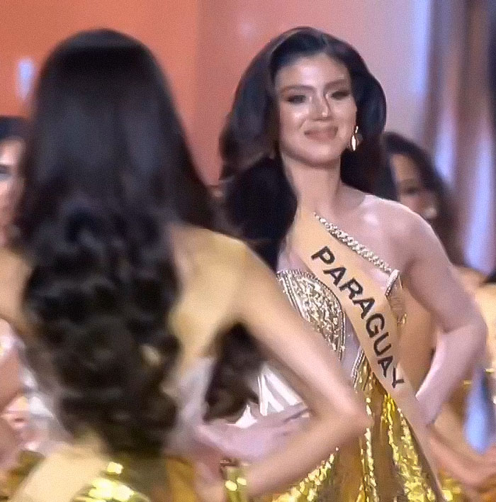 Miss Panama onstage in a gold dress wearing a sash, experiencing a painfully awkward moment during a beauty pageant event. Miss Panama onstage in a gold dress wearing a sash, experiencing a painfully awkward moment during a beauty pageant event.