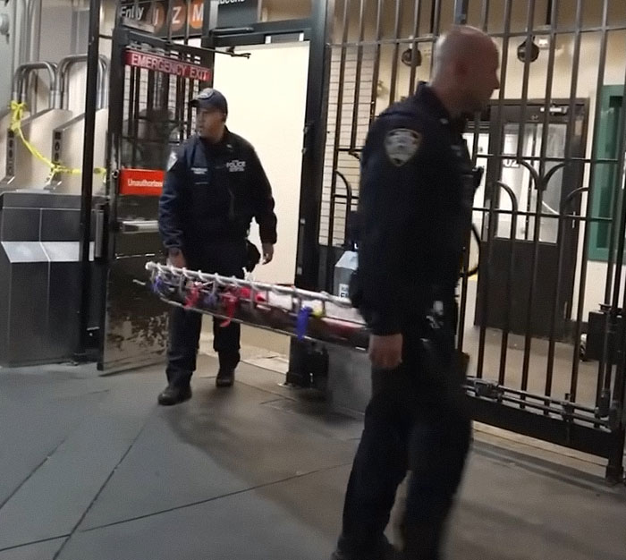 Zwei Polizisten tragen eine Trage in eine U-Bahn-Station, nachdem eine 12-Jährige beim U-Bahn-Surfen ums Leben gekommen ist. Zwei Polizisten tragen eine Trage in eine U-Bahn-Station, nachdem eine 12-Jährige beim U-Bahn-Surfen ums Leben gekommen ist.