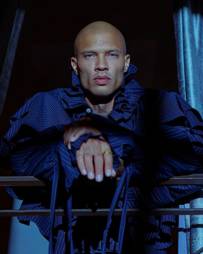 Bald man known as world's hottest felon at 41, wearing a dark ruffled shirt and staring confidently into the camera. Bald man known as world's hottest felon at 41, wearing a dark ruffled shirt and staring confidently into the camera.