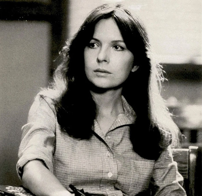 Diane Keaton in a black and white portrait, capturing a serious expression and natural long hair in a casual shirt. Diane Keaton in a black and white portrait, capturing a serious expression and natural long hair in a casual shirt.