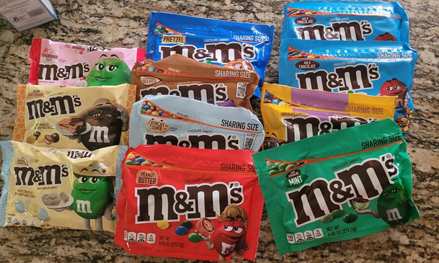 Various flavors of M&M’s candy in sharing size bags arranged on a countertop for Halloween candy ranking in 2025