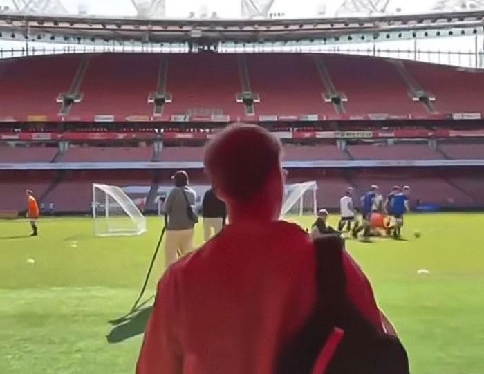 Young man with leg amputation watching a sports field, sharing his story after attending a rock concert incident. Young man with leg amputation watching a sports field, sharing his story after attending a rock concert incident.