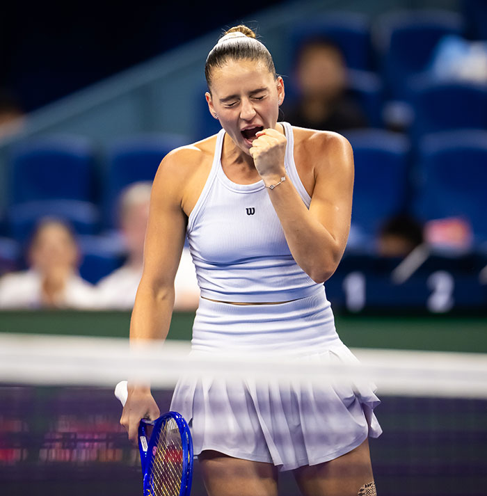 Tennis star celebrating on court during intense match, highlighting fierce rivalry and testosterone remark controversy. Tennis star celebrating on court during intense match, highlighting fierce rivalry and testosterone remark controversy.