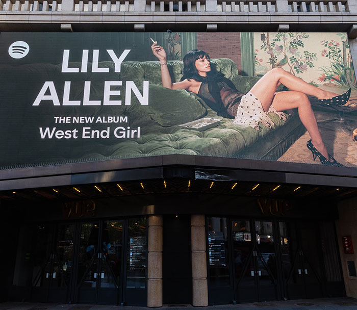 Billboard showing a woman reclining on a sofa with text referencing David Harbour's viral atrocious interaction involving a woman half his age. Billboard showing a woman reclining on a sofa with text referencing David Harbour's viral atrocious interaction involving a woman half his age.