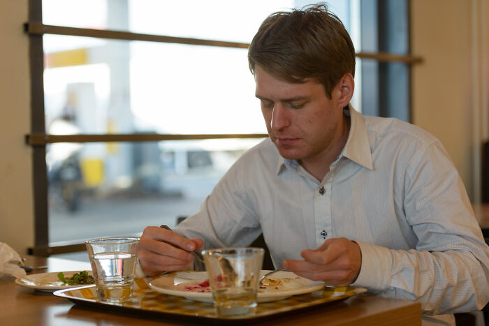 Man sitting at a restaurant table finishing his meal, illustrating restaurant staff tales about bill and money issues.