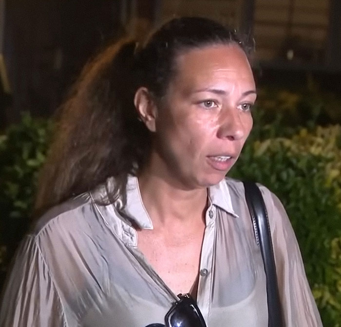 Frau mit zurückgebundenem langen Haar und hellem Hemd diskutiert nachts im Freien über den Unfall eines 12-Jährigen beim Subway-Surfen und die Schuld der Eltern. Frau mit zurückgebundenem langen Haar und hellem Hemd diskutiert nachts im Freien über den Unfall eines 12-Jährigen beim Subway-Surfen und die Schuld der Eltern.