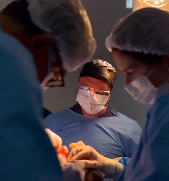 Medical team performing surgery in an operating room, highlighting complications from popular fox eyes cosmetic procedure. Medical team performing surgery in an operating room, highlighting complications from popular fox eyes cosmetic procedure.