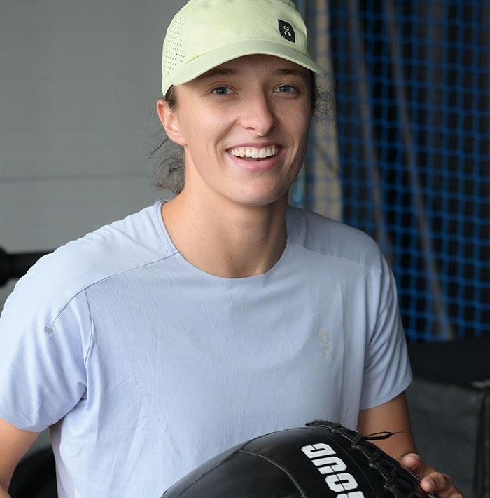 Tennis star smiling in athletic wear during training session amid testosterone remark controversy and rival's response. Tennis star smiling in athletic wear during training session amid testosterone remark controversy and rival's response.