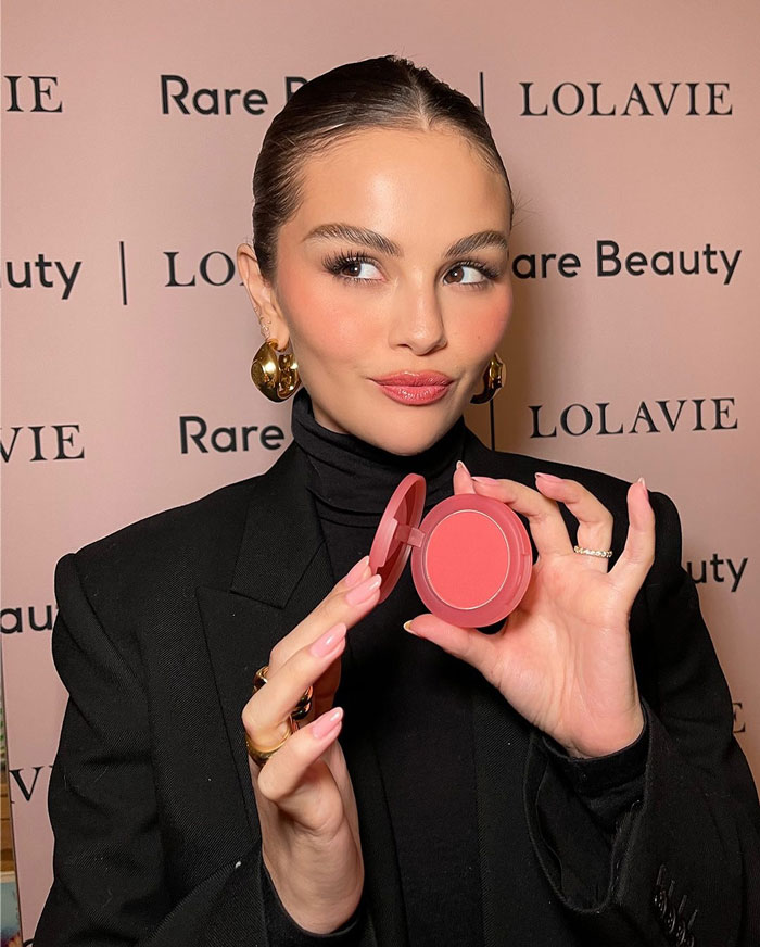 Young woman with flawless makeup holding a compact blush, illustrating Selena Gomez's face in new music video shock. Young woman with flawless makeup holding a compact blush, illustrating Selena Gomez's face in new music video shock.