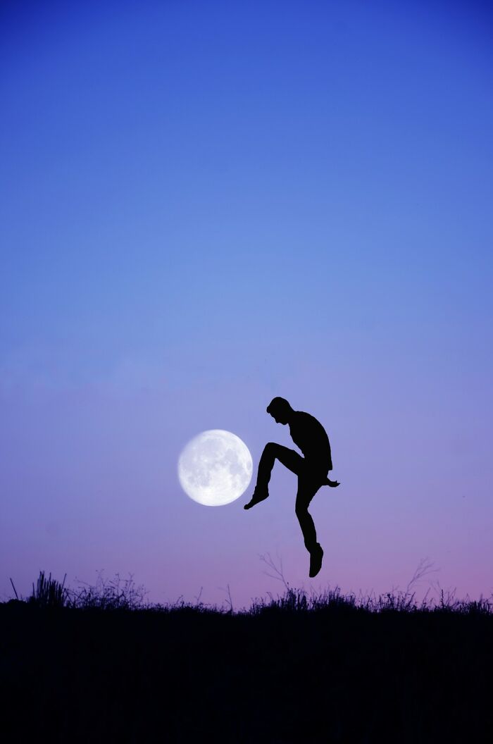 Silhouette of a basketball player jumping near a hoop with the moon in the background in an award-winning photo.