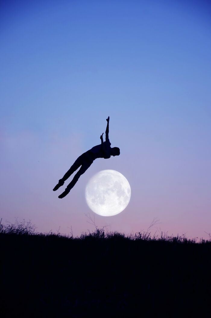 Silhouette of a basketball player jumping near a hoop with the moon in the background in an award-winning photo.
