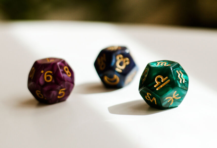 Three colorful 12-sided dice with gold numbers and symbols, representing the 999 angel number concept. Three colorful 12-sided dice with gold numbers and symbols, representing the 999 angel number concept.